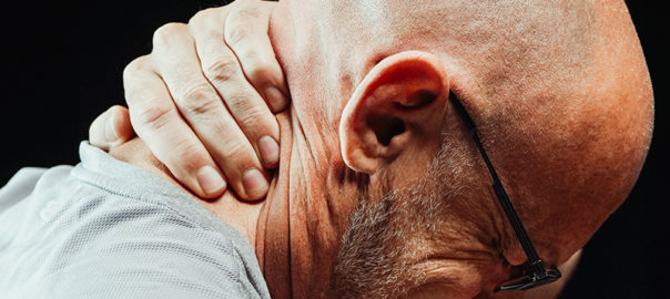 Man rubbing his injured neck in work-related accident